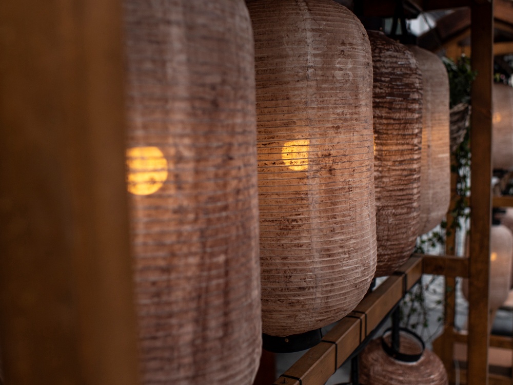 Clair Obscur Design, décoration intérieure Wabi-Sabi, design minimaliste, matériaux naturels. Luminaires suspendus en papier de riz brun délavé, style rustique, finition jute, intégrant éléments naturels, slow living, décor minimaliste, design écoresponsable, textures naturelles, décoration Wabi-Sabi, éclairage doux, matériaux durables, reflétant un intérieur apaisant et organisé.