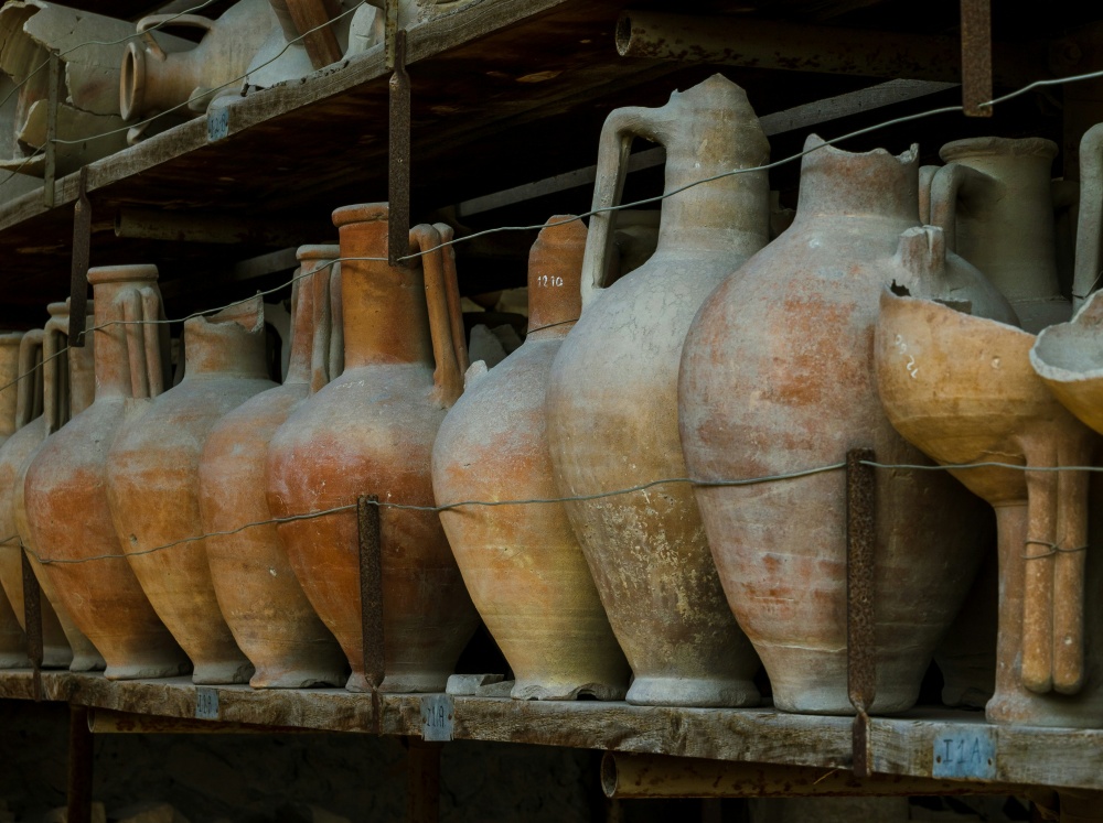 Clair Obscur Design, décoration intérieure Wabi-Sabi, design minimaliste, matériaux naturels. Collection de vases en poterie et pots en terre cuite disposés sur tablettes anciennes, créant un décor rustique et authentique, reflétant le slow living, le désencombrement maison, le design écoresponsable, la décoration naturelle, le minimalisme fonctionnel, et une ambiance apaisante, organique, et harmonieuse.