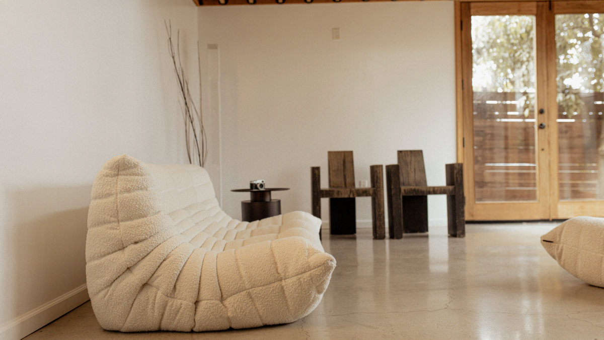 Clair Obscur Design, designer d'intérieur virtuel, design intérieur Canada, organisation maison, décoration Airbnb, Salon Japandi, design intérieur contemporain, séjour minimaliste, idée déco salon, aménagement durable et éco-conscient, déco naturelle avec canapé blanc bas, chaises rustiques en bois, table métal, murs blancs, branches décoratives, suspensions bois.