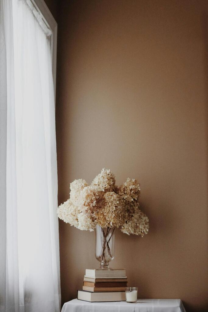 Clair Obscur Design, virtual interior designer, interior design Canada, home organization, Airbnb decoration, Minimalist interior design, neutral colors, dried flowers vase, decorative books, natural linen curtains, calming ambiance, simple living style, Scandinavian aesthetic.